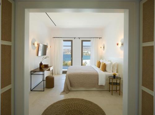 a bedroom with a bed with a view of the ocean at Bonzoe Suites & Villas in Mýkonos City