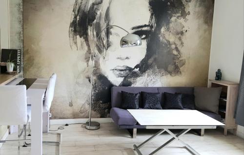 un salon avec un canapé violet et une fresque murale. dans l'établissement Happydays Cannes spacieux duplex 70m2, à Cannes