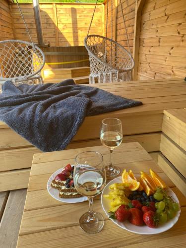 a table with two glasses of wine and a plate of fruit at UBYTOVÁNÍ S WELLNESS in Dolní Dobrouč