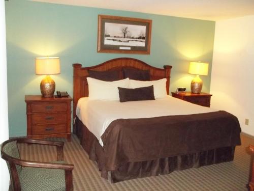a bedroom with a bed with two night stands and two lamps at Fox Run Association, a VRI resort in Lake Lure