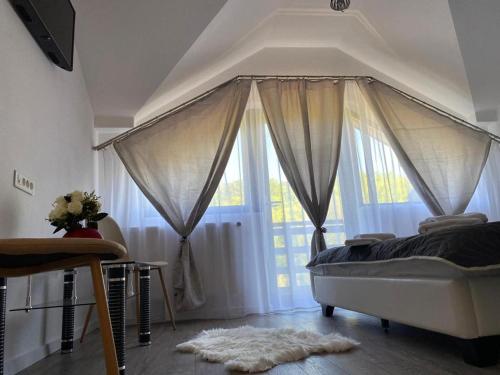 a bedroom with a bed and a large window at Perla Muntilor Ponoarele, Padurea de liliac in Ponoarele
