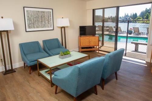 a living room with two chairs and a table and a tv at Lakeshore Inn in Lake Oswego