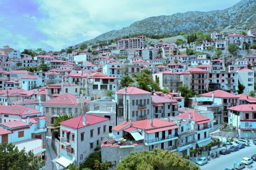 a group of buildings with pink roofs on a mountain at Clock Tower Aparthotel in Arachova