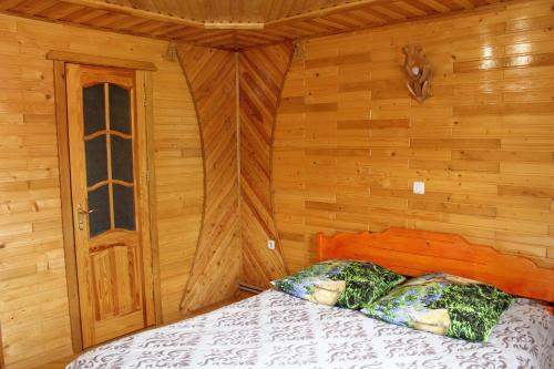 a bedroom with a bed in a wooden room at Manor "U Bervinovy" in Yaremche