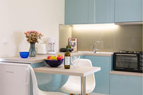 a kitchen with a table with a bottle of wine and a bowl of fruit at Bellevue Suites in Agios Nikolaos