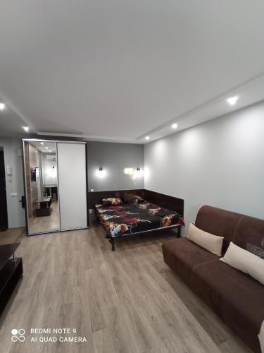 a living room with a couch and a mirror at НЕ ВИМИКАЮТЬ СВІТЛО lark apartment in Dnipro
