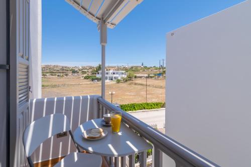 a table and chairs on a balcony with a view of the ocean at Orama Milos in Adamas