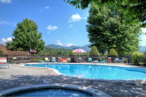 una gran piscina con sillas y árboles en Highland Manor Inn, en Townsend