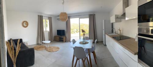 cocina y sala de estar con mesa y sillas en Casa Fondale en Santa-Reparata-di-Balagna