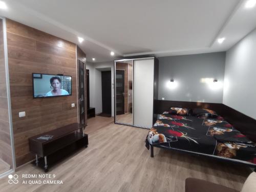 a bedroom with a bed and a flat screen tv at lark apartment in Dnipro