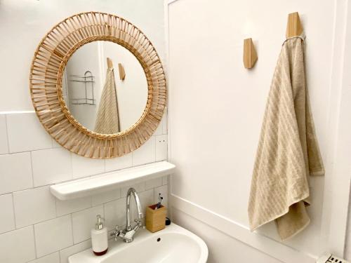a bathroom with a mirror and a sink at Napsugár Retro Apartman in Gárdony