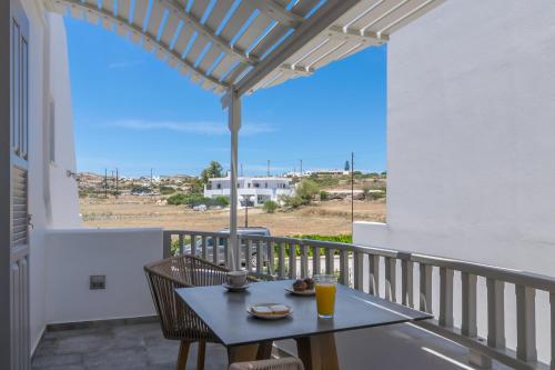 a table and chairs on a balcony with a view at Orama Milos in Adamas