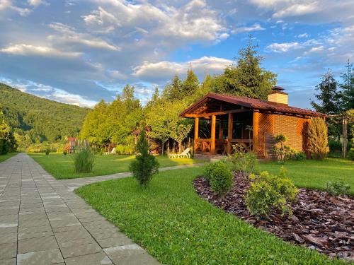 eine Hütte inmitten eines Rasenplatzes mit einem Weg in der Unterkunft У Аліни in Solotschyn