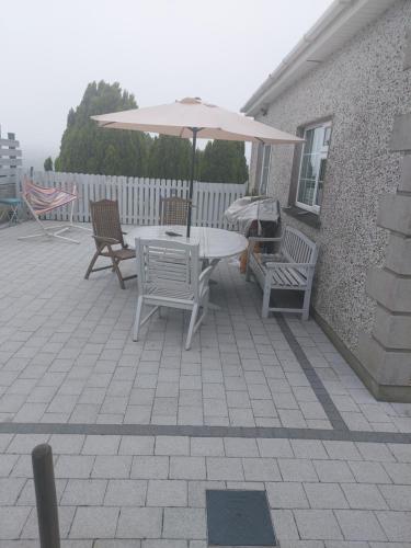 a table and chairs with an umbrella on a patio at Amberley in Gorey