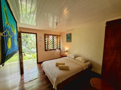 ein Schlafzimmer mit einem Bett und einem großen Fenster in der Unterkunft Cabinas Tortuguero in Tortuguero