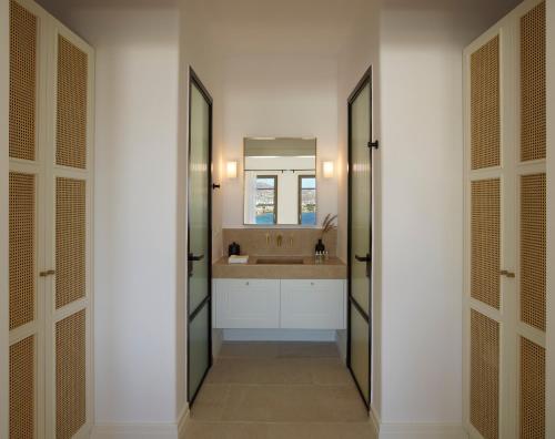 a bathroom with a sink and a mirror at Bonzoe Suites & Villas in Mýkonos City