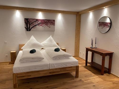 a bedroom with a bed and a table and a mirror at Neurenovierte Ferienwohnung Xaver in Holzkirchen