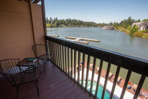 a balcony with two chairs and a view of a river at Lakeshore Inn in Lake Oswego