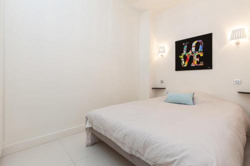 une chambre blanche avec un lit et un tableau sur le mur dans l'établissement Modern & cozy 150m from the Croisette, à Cannes