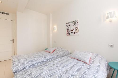 une chambre blanche avec un lit et un tableau sur le mur dans l'établissement Modern & cozy 150m from the Croisette, à Cannes