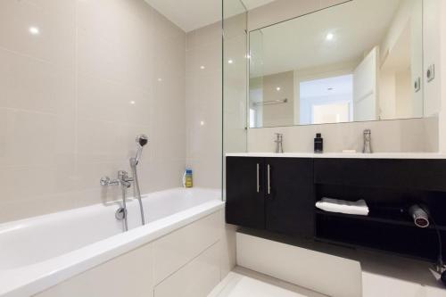 une salle de bain avec une baignoire, un lavabo et un miroir dans l'établissement Modern & cozy 150m from the Croisette, à Cannes