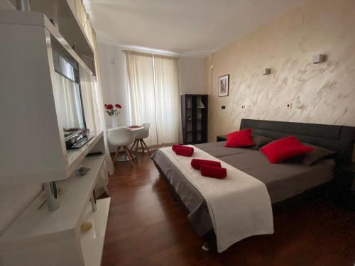- une chambre avec un lit doté d'oreillers rouges dans l'établissement Apartman Torre, à Hvar
