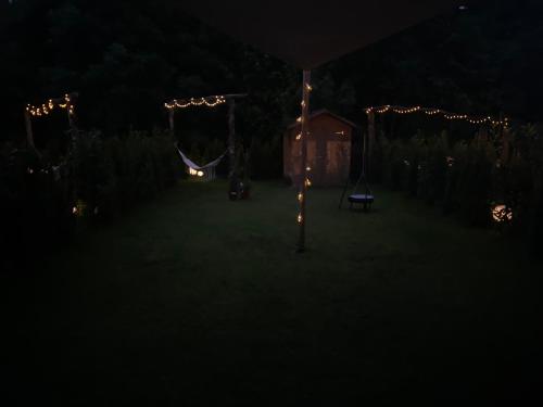 a dark yard with a hammock and lights at night at Neurenovierte Ferienwohnung Xaver in Holzkirchen