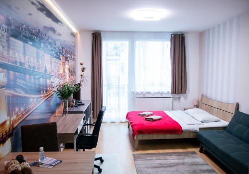 Schlafzimmer mit einem Bett, einem Schreibtisch und einem Tisch in der Unterkunft Keleti Aparthotel in Budapest