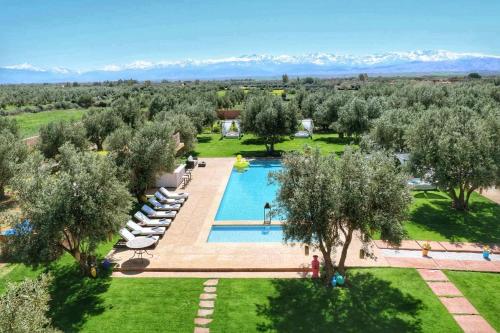 an overhead view of a pool with trees and mountains at Villa Kristy in Marrakech