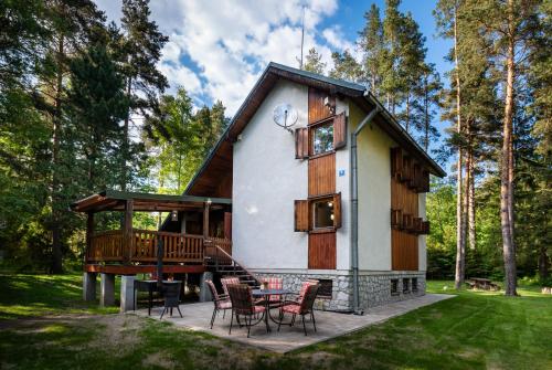 a small house with a porch and a table and chairs at Chata Dáša High Tatras in Mlynčeky