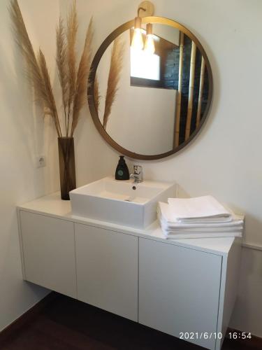 a bathroom with a white sink and a mirror at Casa das Andorinhas in Póvoa de Lanhoso