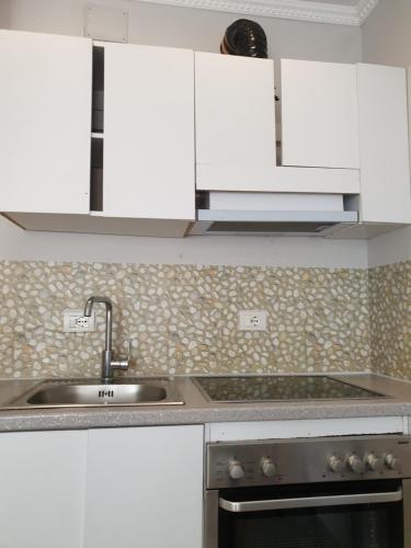 a kitchen with white cabinets and a sink at Villa 27 Residence in Tirana