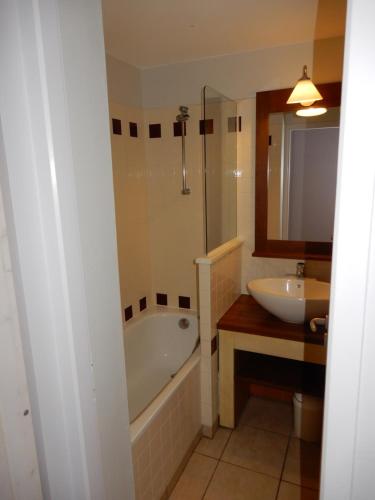 une salle de bain avec une baignoire et un lavabo dans l'établissement Appartement au Domaine du Golf dans résidence de vacance, à Moliets-et-Maa