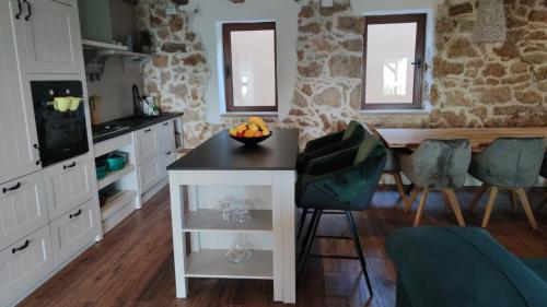 a kitchen with a table with a bowl of fruit on it at Stone hause Noa in Rab