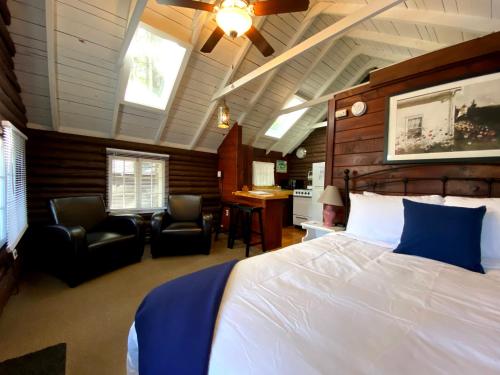 una camera da letto con un letto, due sedie e una scrivania di Pine Grove Cottages a Lincolnville