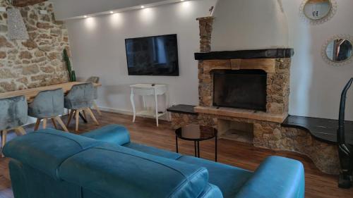 a living room with a blue couch and a fireplace at Stone hause Noa in Rab