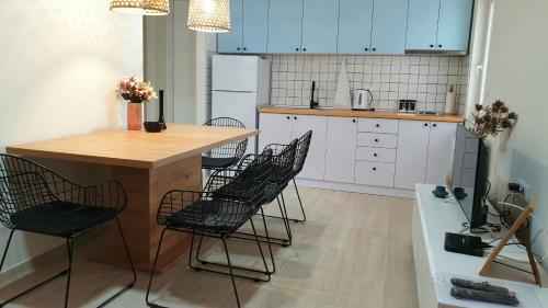 a kitchen with a wooden table and black chairs at Lovely Private Flats FREE parking in Novi Sad