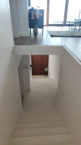 two views of a hallway with a stairway at Stone hause Noa in Rab