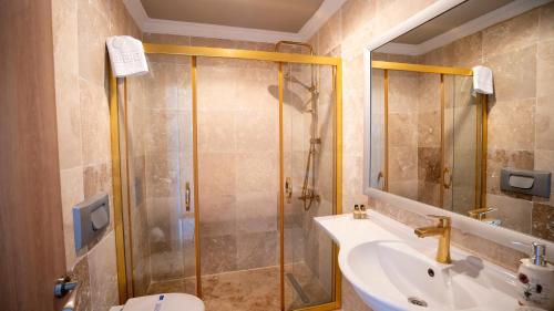 La salle de bains est pourvue d'une douche, d'un lavabo et de toilettes. dans l'établissement Ebruli Hotel Cunda, à Ayvalık