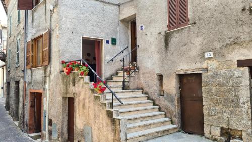 a stone building with stairs leading up to a door at Amazing Lake View in Castel di Tora