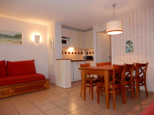 une cuisine et une salle à manger avec une table et des chaises dans l'établissement Appartement au Domaine du Golf dans résidence de vacance, à Moliets-et-Maa