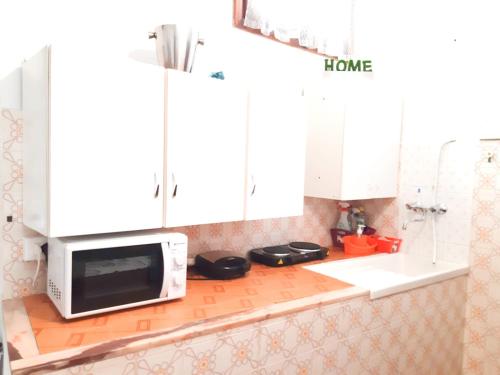 a kitchen with white cabinets and a microwave on a counter at The Terrace in Vernazza