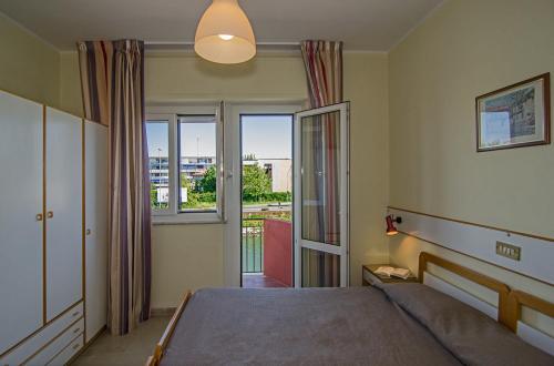 a bedroom with a bed and a large window at Hotel Laurin in Lido di Camaiore