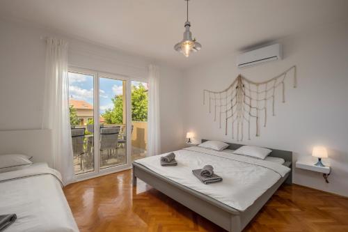 a bedroom with two beds and a large window at APP BLUE, SELCE in Selce