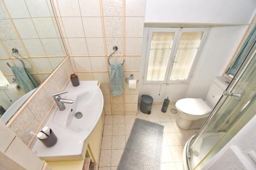 a small bathroom with a sink and a toilet at Roses Apartment in Corfu city centre in Corfu
