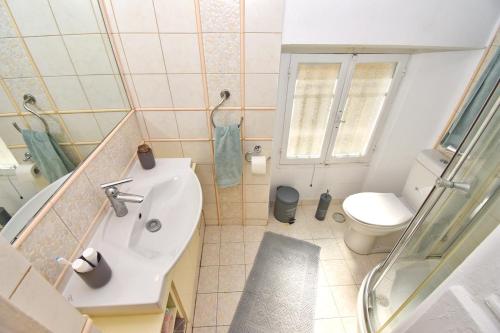 a small bathroom with a sink and a toilet at Roses Apartment in Corfu city centre in Corfu Town