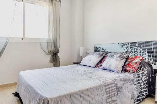 een slaapkamer met een bed en een groot raam bij Fantastic 2 bedroom fully furnished modern apartment in walking distance to all amenities in Villamartin