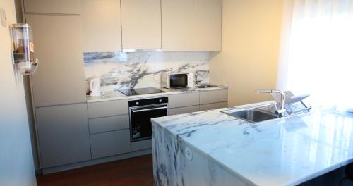 a kitchen with a marble counter top and a sink at Woof & Sun in Esmoriz