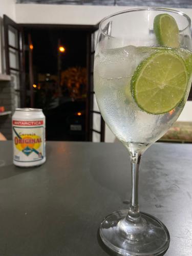 a drink in a glass with a lime in it at Casa da Si Hostel in Ubatuba