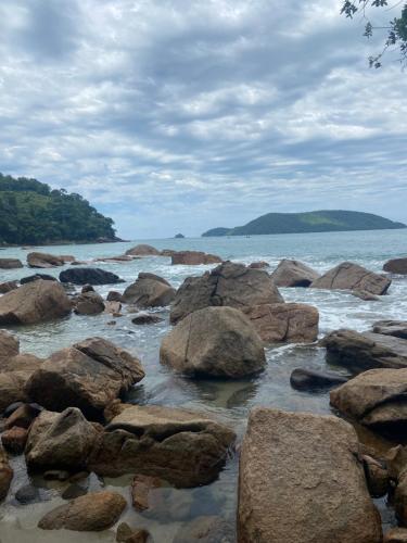 a group of rocks in the water on a beach at Casa da Si Hostel in Ubatuba